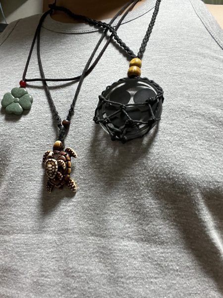 Maui turtle and four-leaf clover necklaces, and a self-made family crest on quartz glass